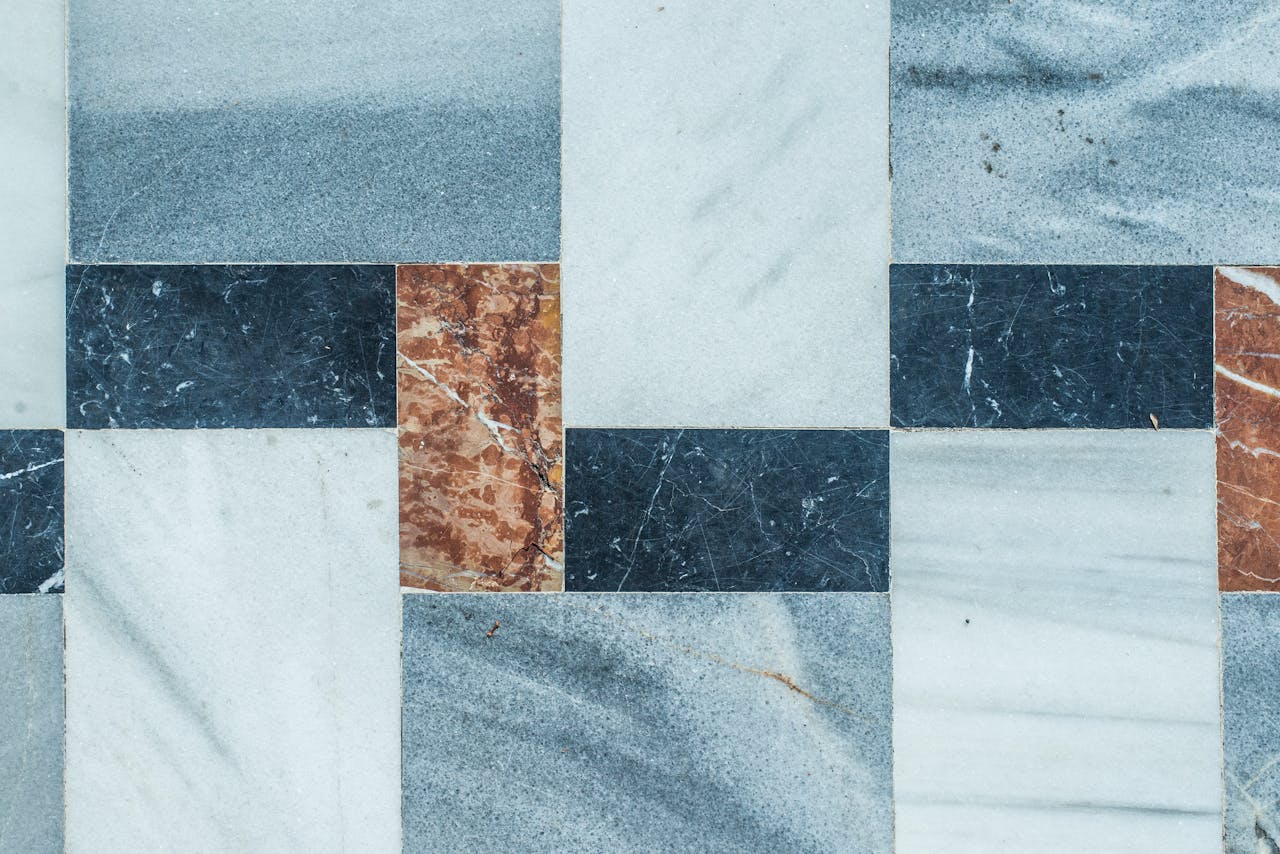 gallery-3 Close-up of a geometric marble tile pattern with natural texture colors.